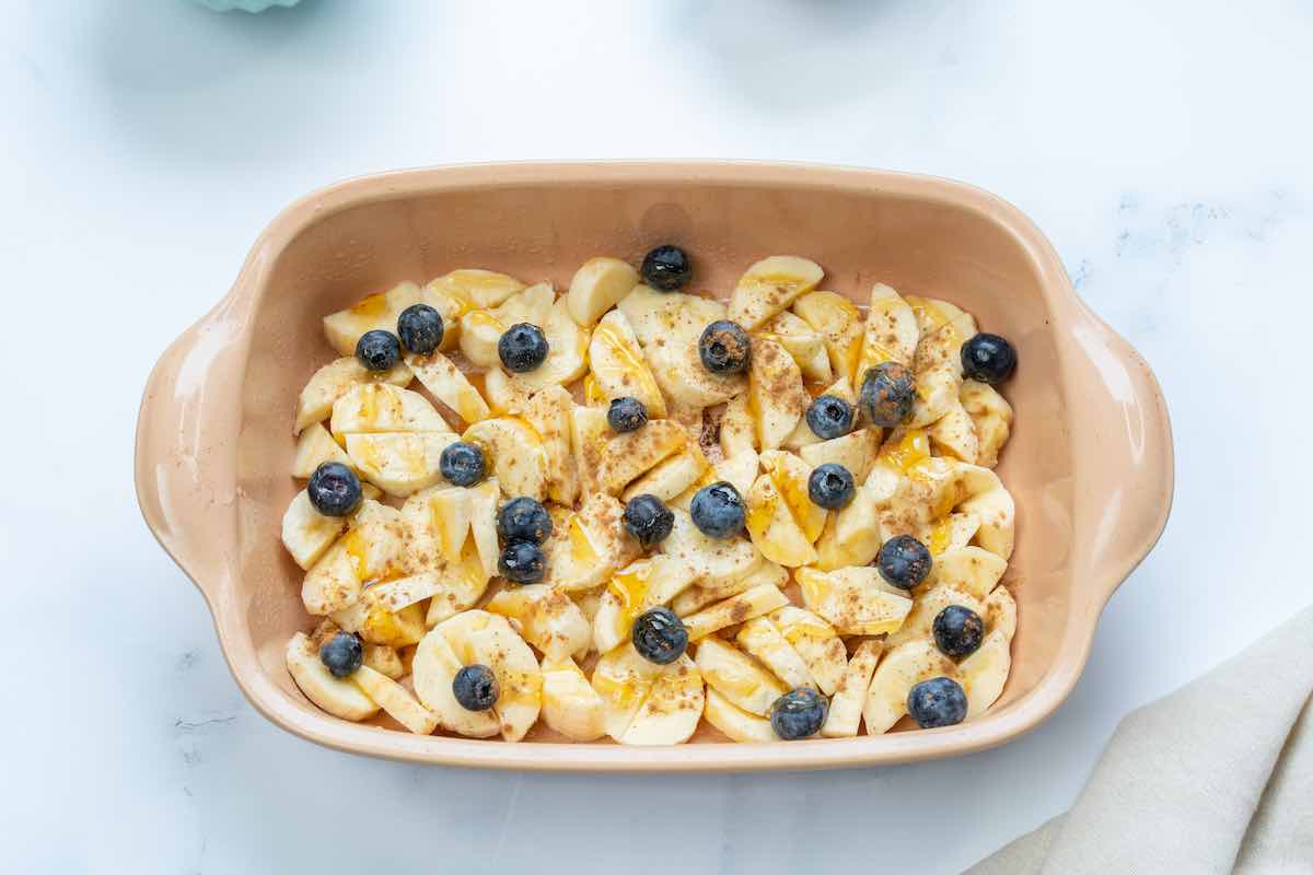 bananas, blueberries, and honey in a bowl.