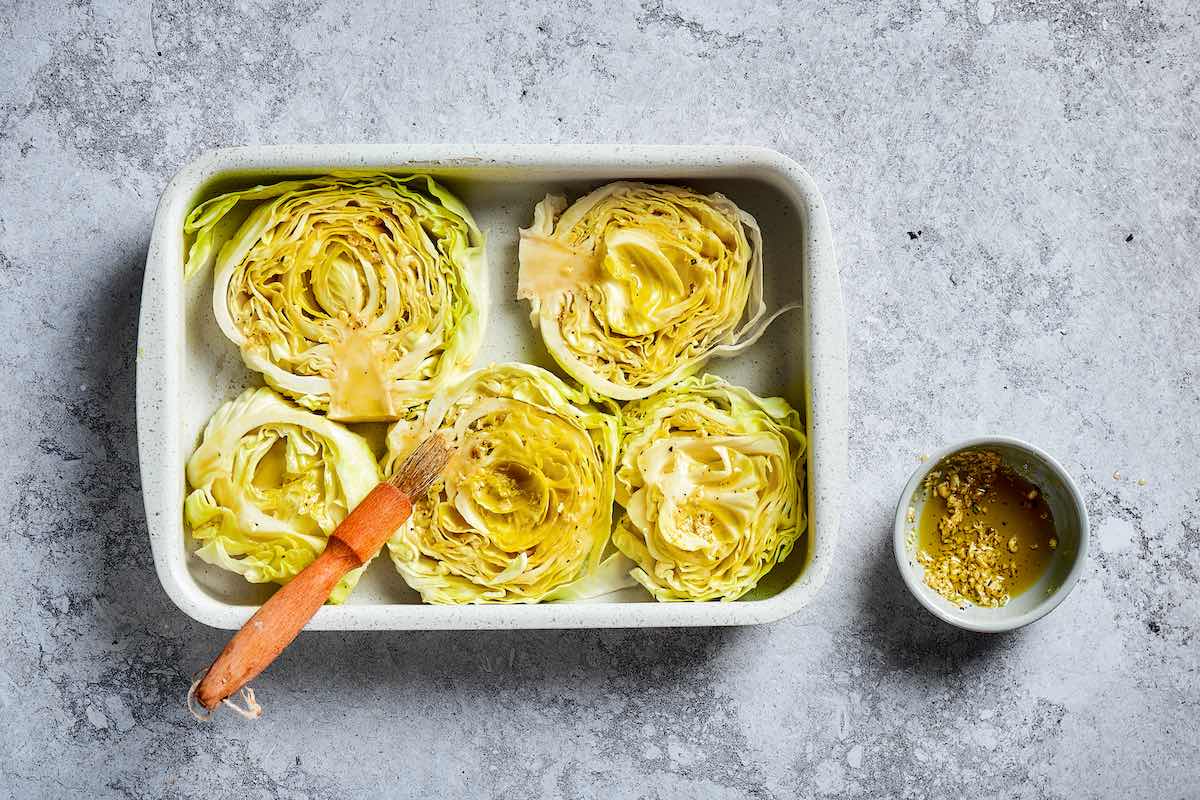 sliced raw cabbage steaks with garlic butter brushed on top.