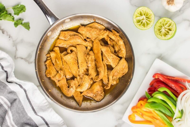 chicken fajita marinade with chicken in a skillet.