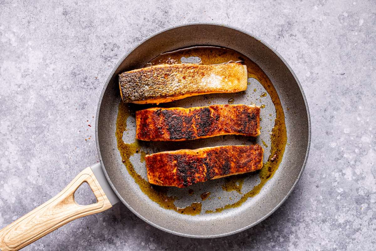 seared salmon fillets in a skillet.