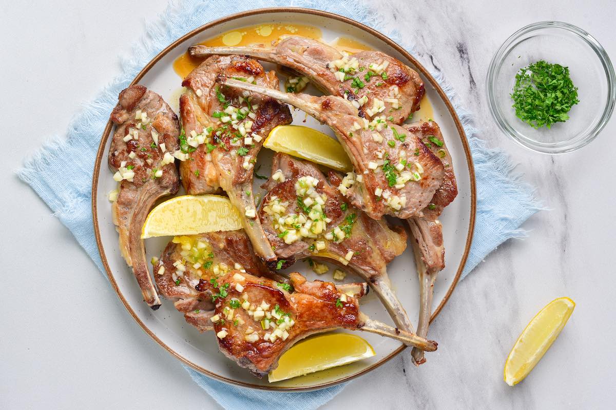 adding marinade to lamb chops.