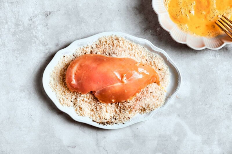 egg washed raw chicken dredged in bread crumbs.