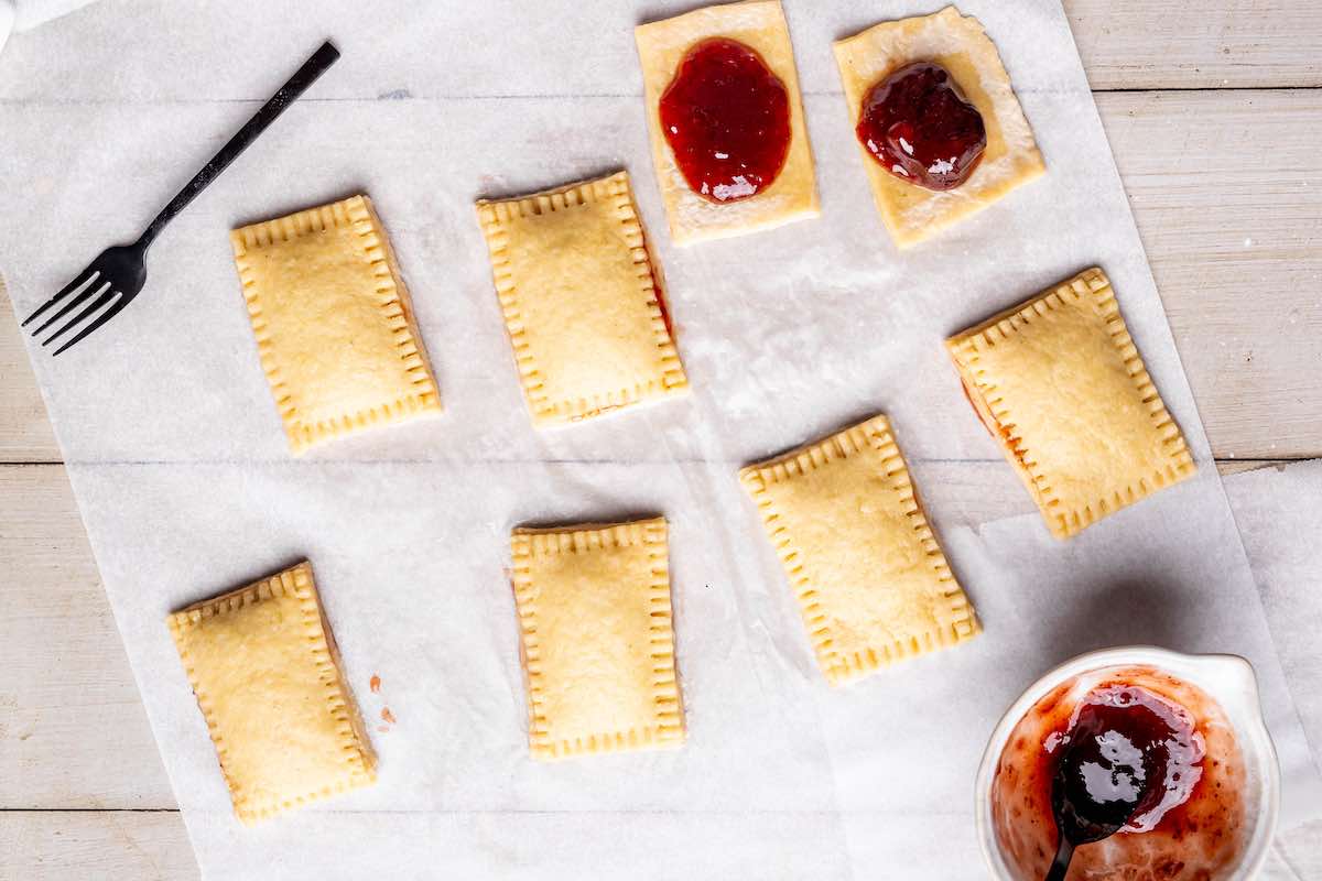 rectangles of dough with drops of strawberry jam on top.