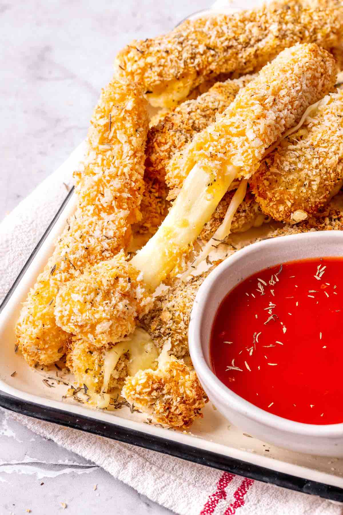 platter of air fryer mozzarella sticks with marinara sauce.