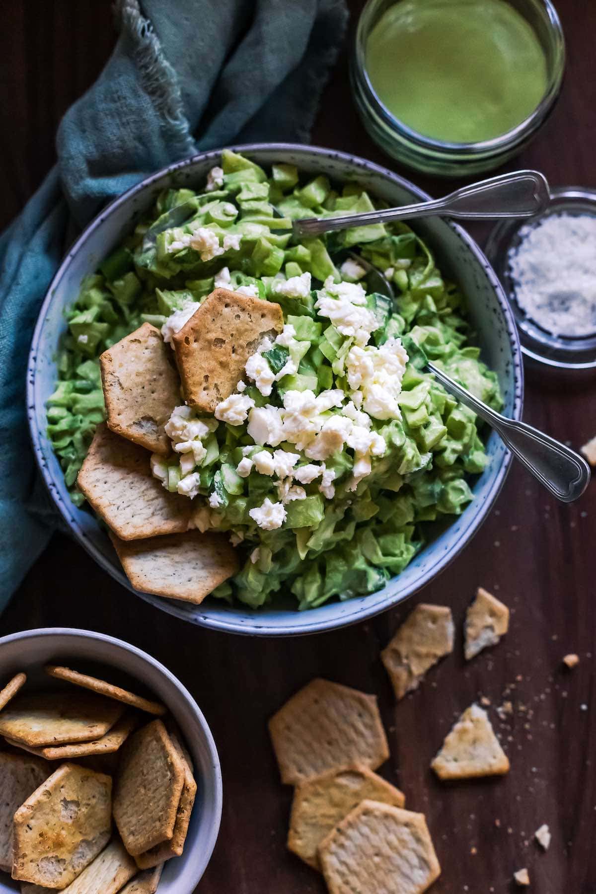 Green goddess salad with crumbled feta and crackers.