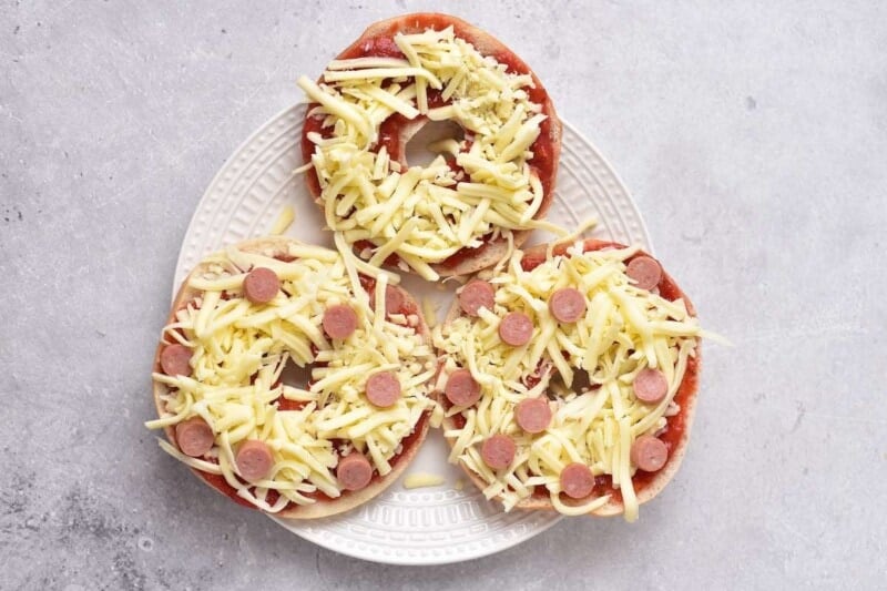 bagel halves with sauce, shredded cheese, and pepperoni.