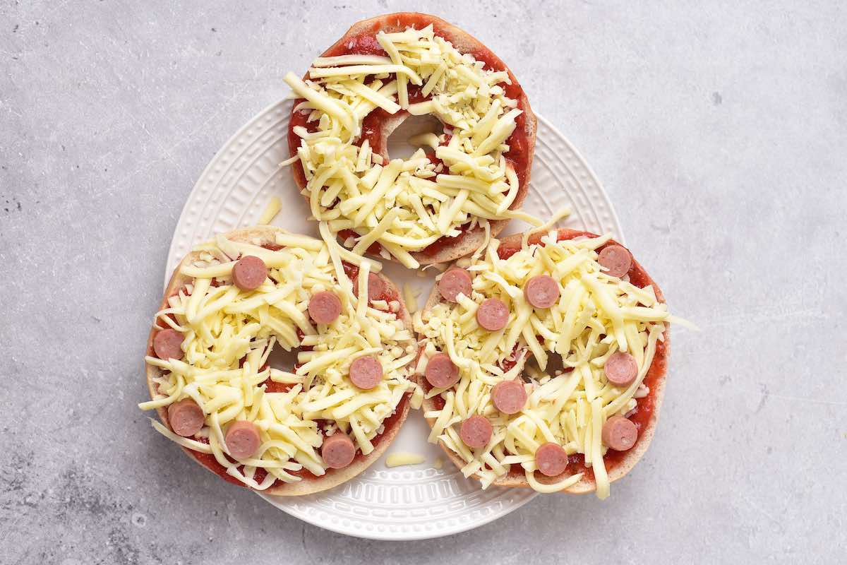 bagel halves with sauce, shredded cheese, and pepperoni.