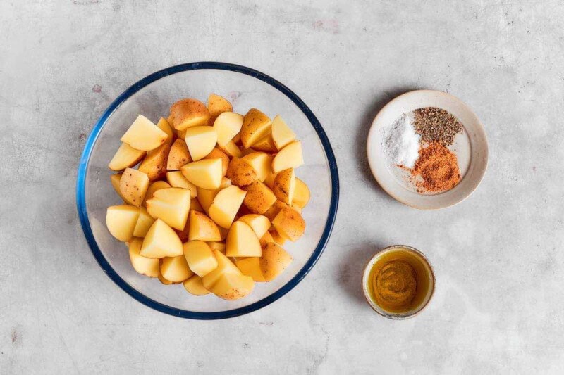 raw potatoes and seasonings in bowls.