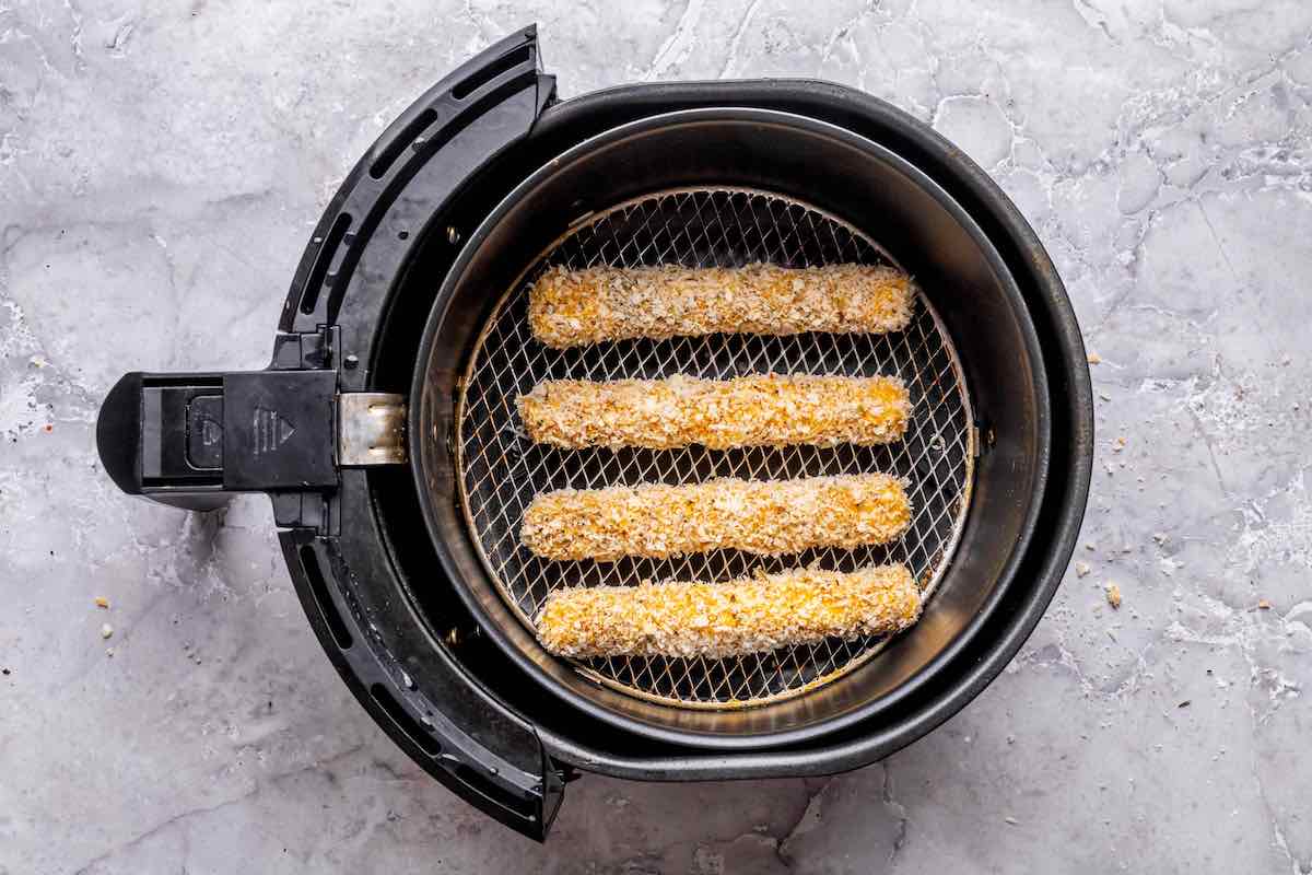 uncooked mozzarella sticks in the air fryer.