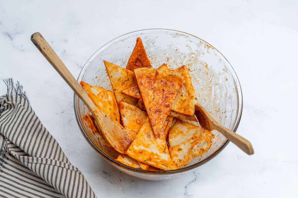 mixing bowl with pita triangles and seasonings.