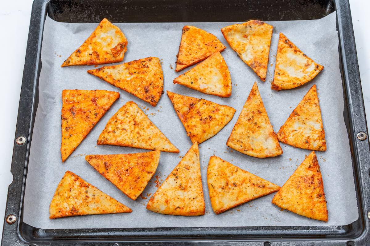 seasoned pita rounds on a baking sheet.