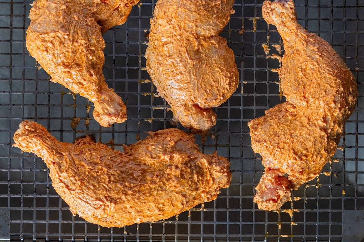 marinated raw chicken on a wire rack.