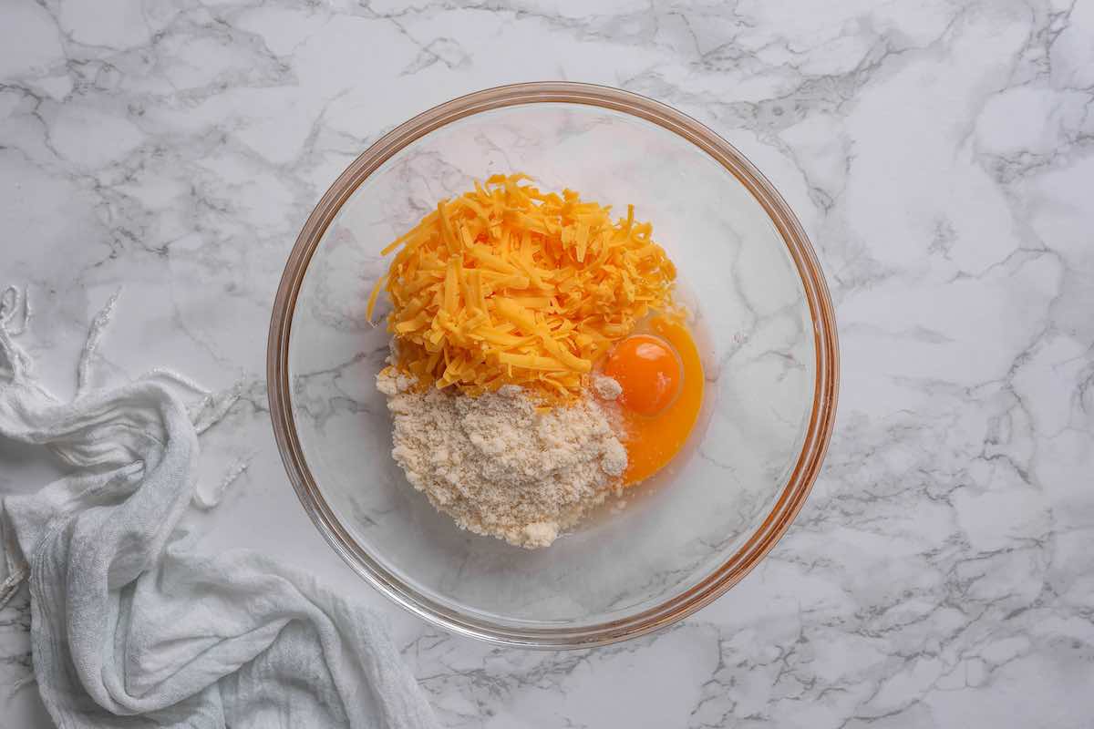 shredded cheese, eggs, and almond flour in a bowl.