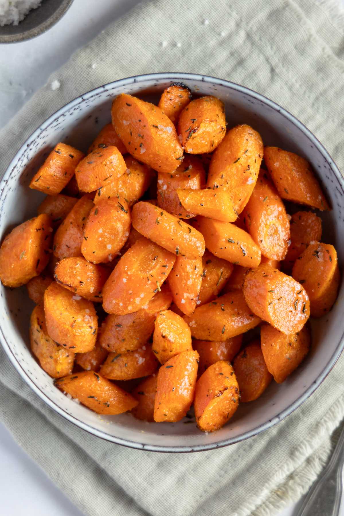air fryer carrots in a bowl with salt and pepper.