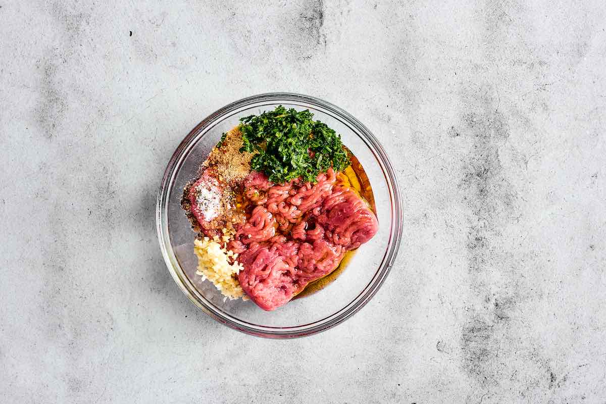 ground turkey, olive oil, garlic, and seasonings in a bowl.