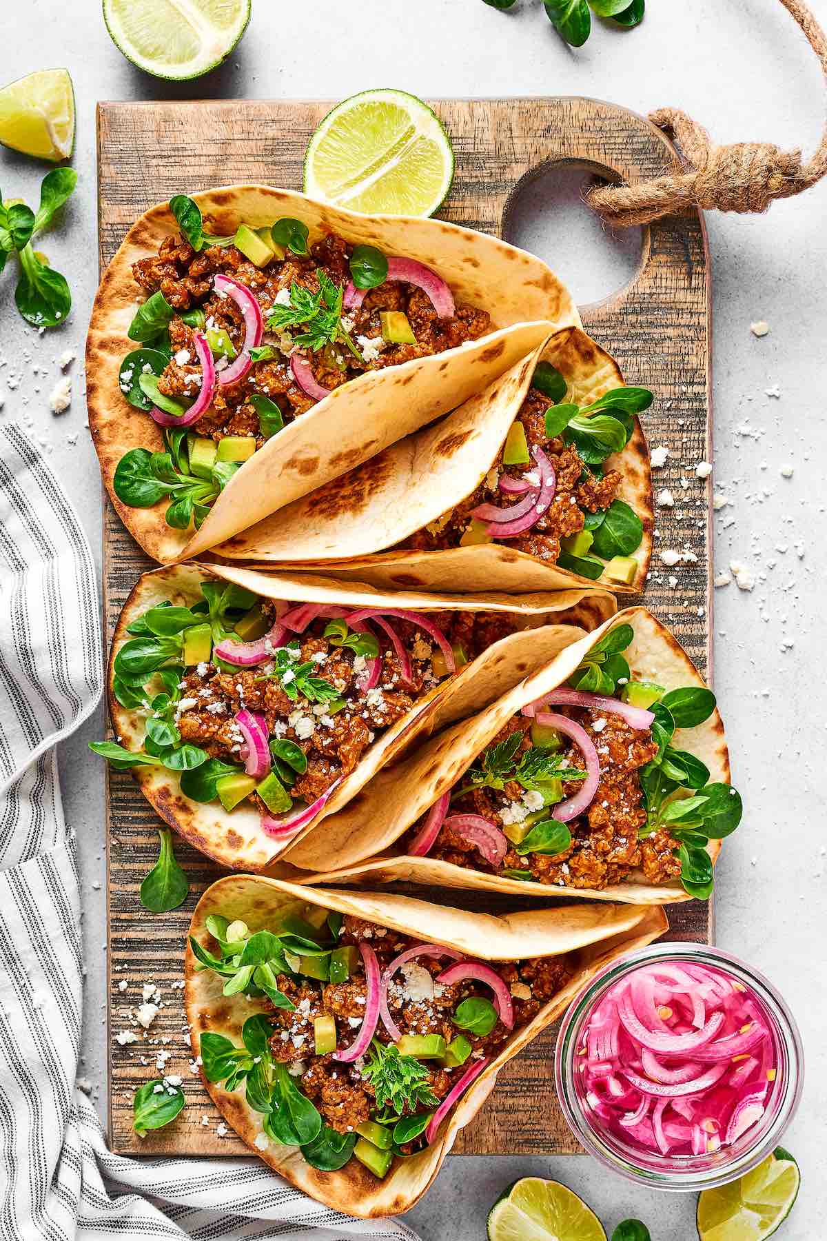 chicken tacos with red onion and microgreens.