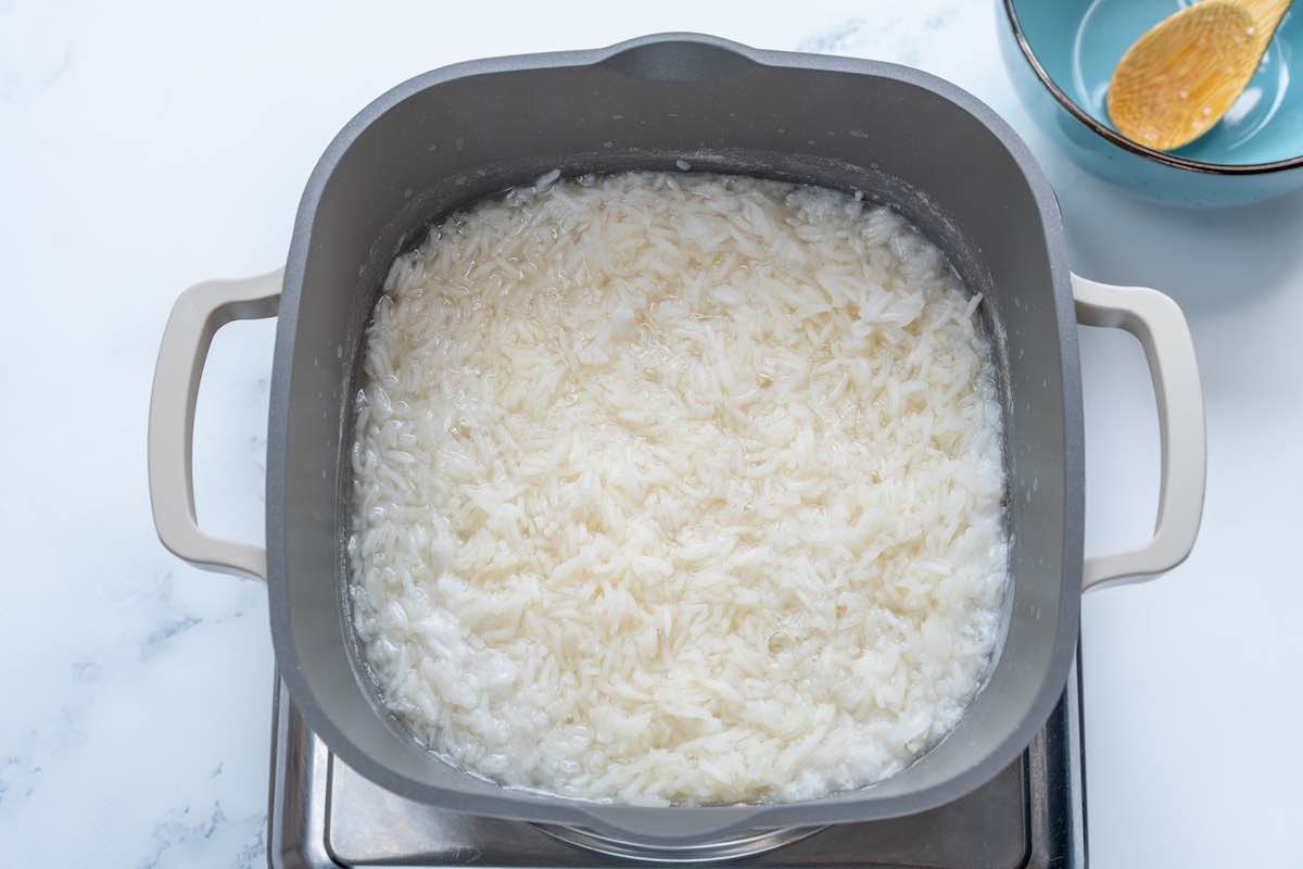 adding rice to boiling water on the stovetop.