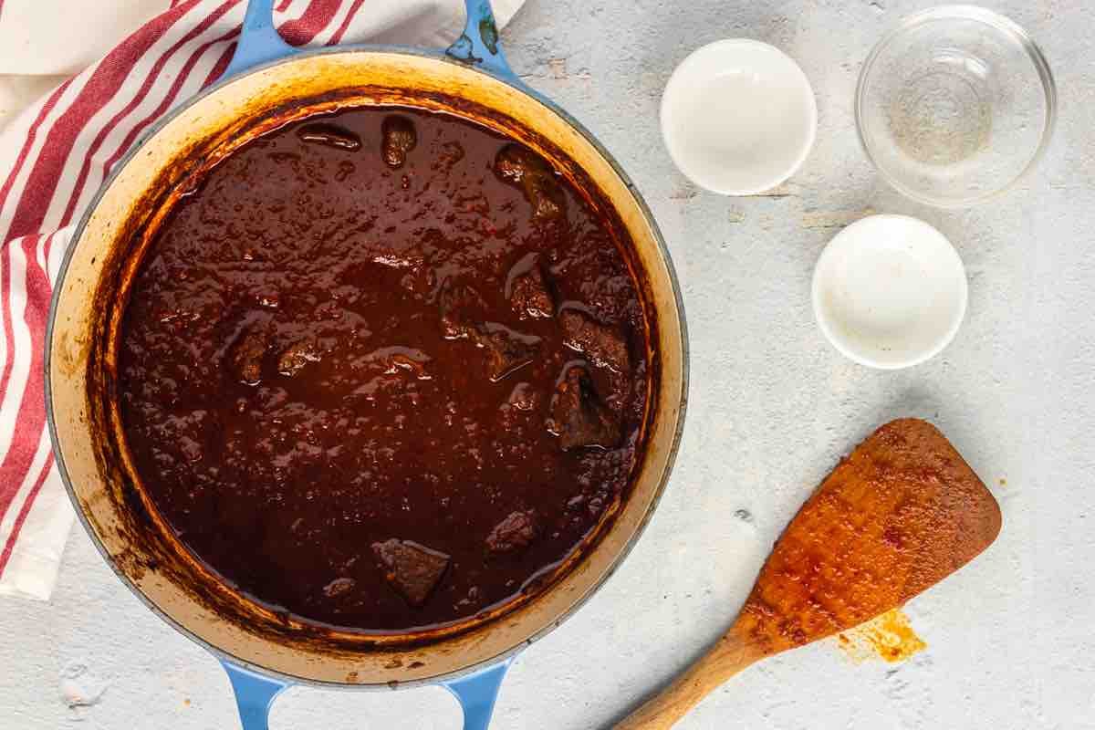 simmering beef birria in a pot.