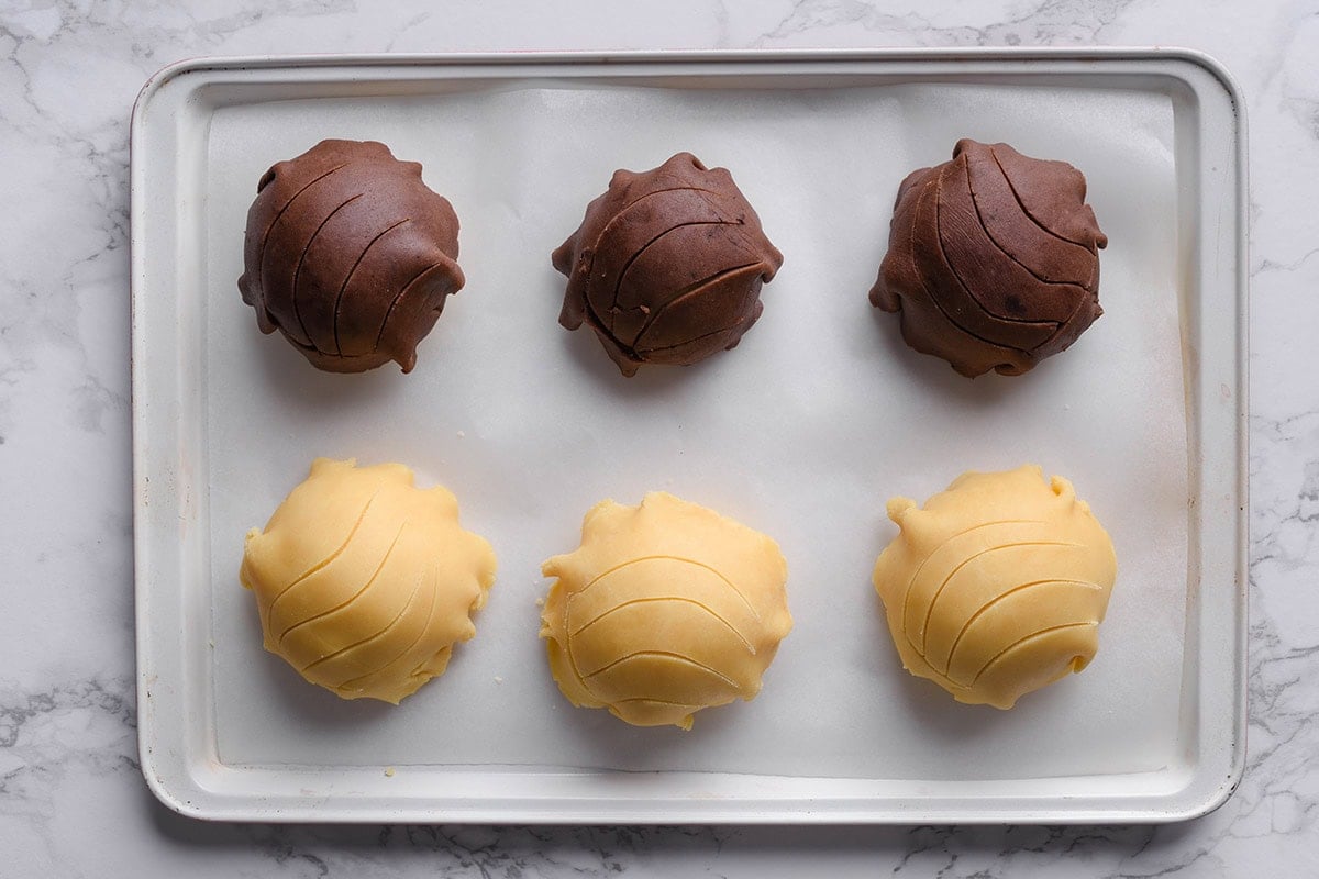 shaped concha on a lined baking sheet.