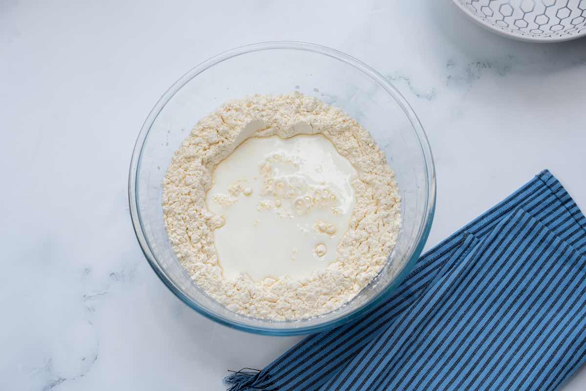 flour with curdled milk mixture in a bowl.