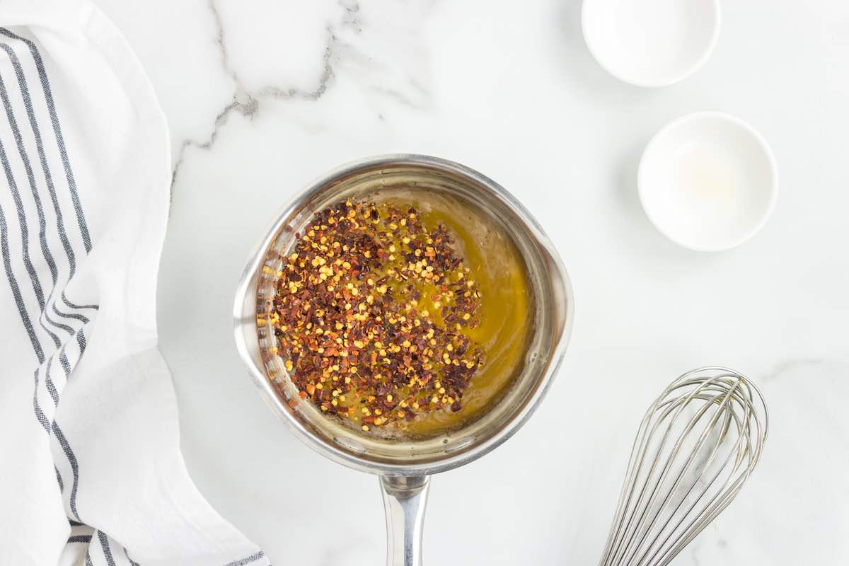honey with red chili flakes being stirred in.
