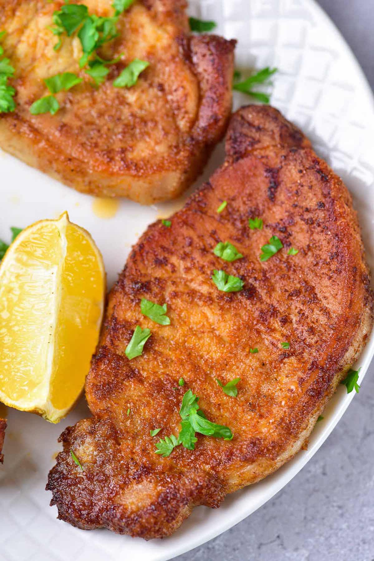 sous vide pork chops with fresh herbs on top.
