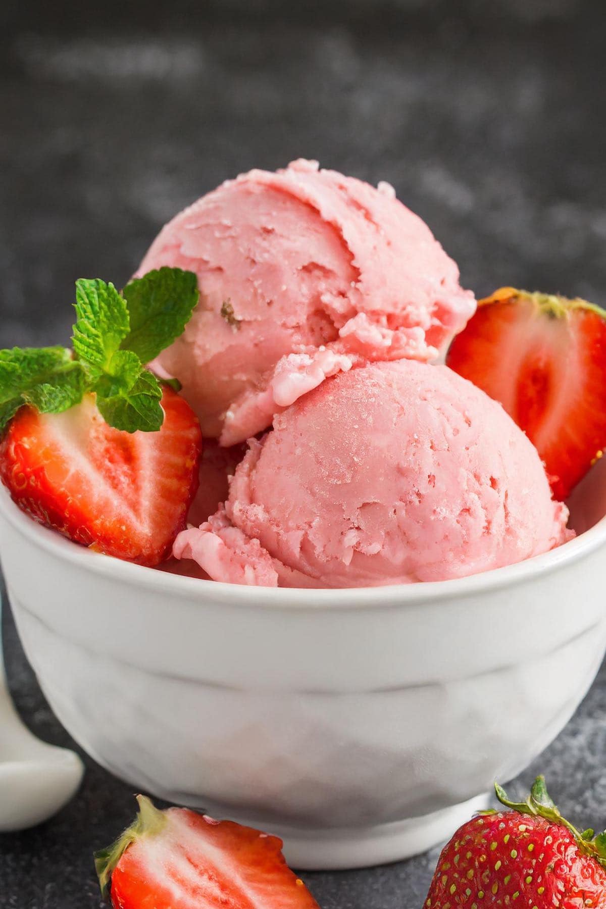 loaf pan with strawberry ice cream in a scoop coming out.