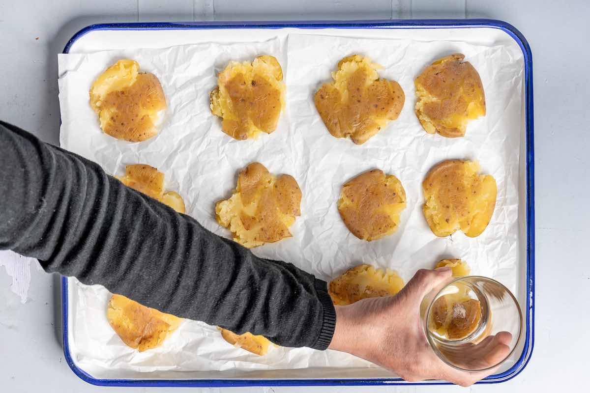 pressing down on boiled potatoes with a glass.