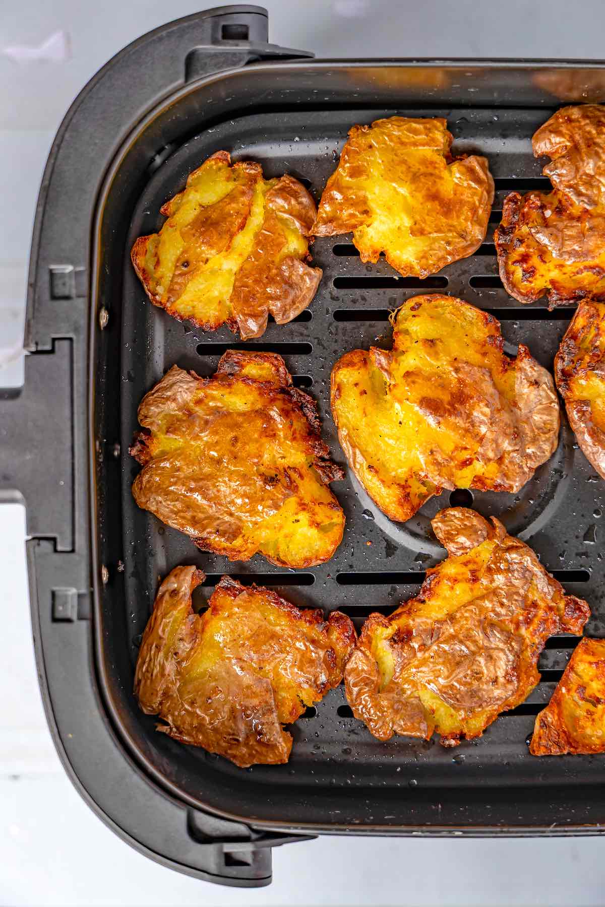 air fried smashed potatoes in the air fryer basket.