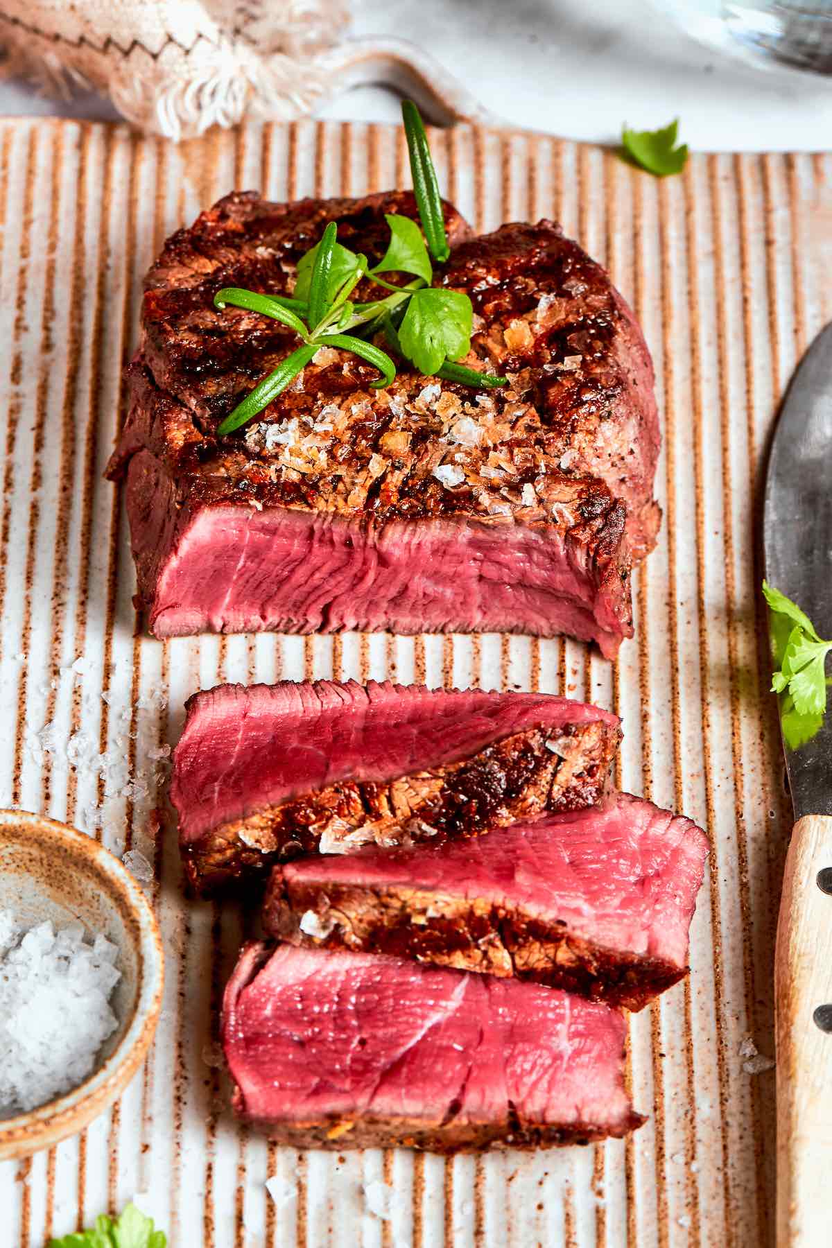 sliced black and blue steak on a chopping board.
