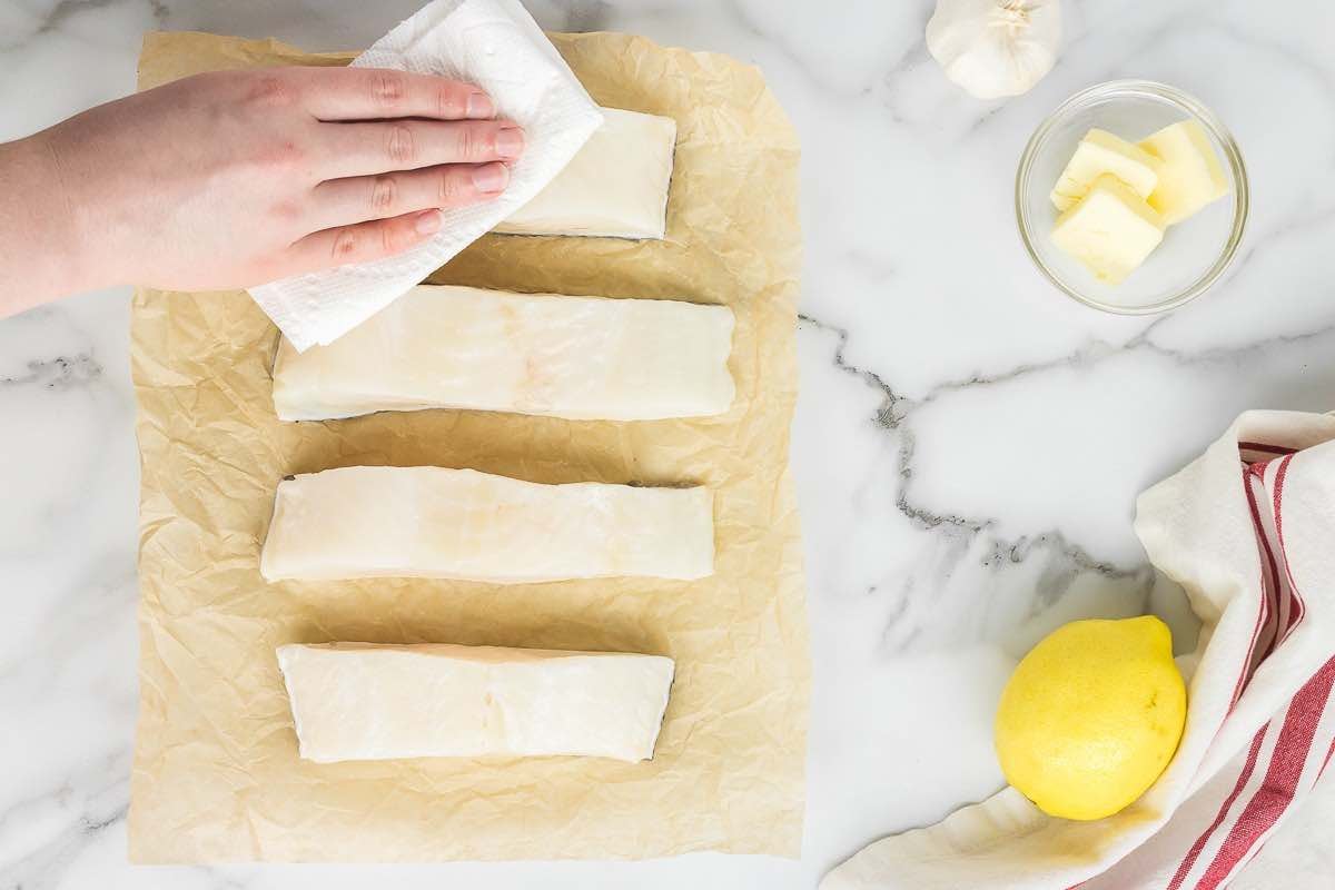 patting dry Chilean sea bass fillets with a paper towel.