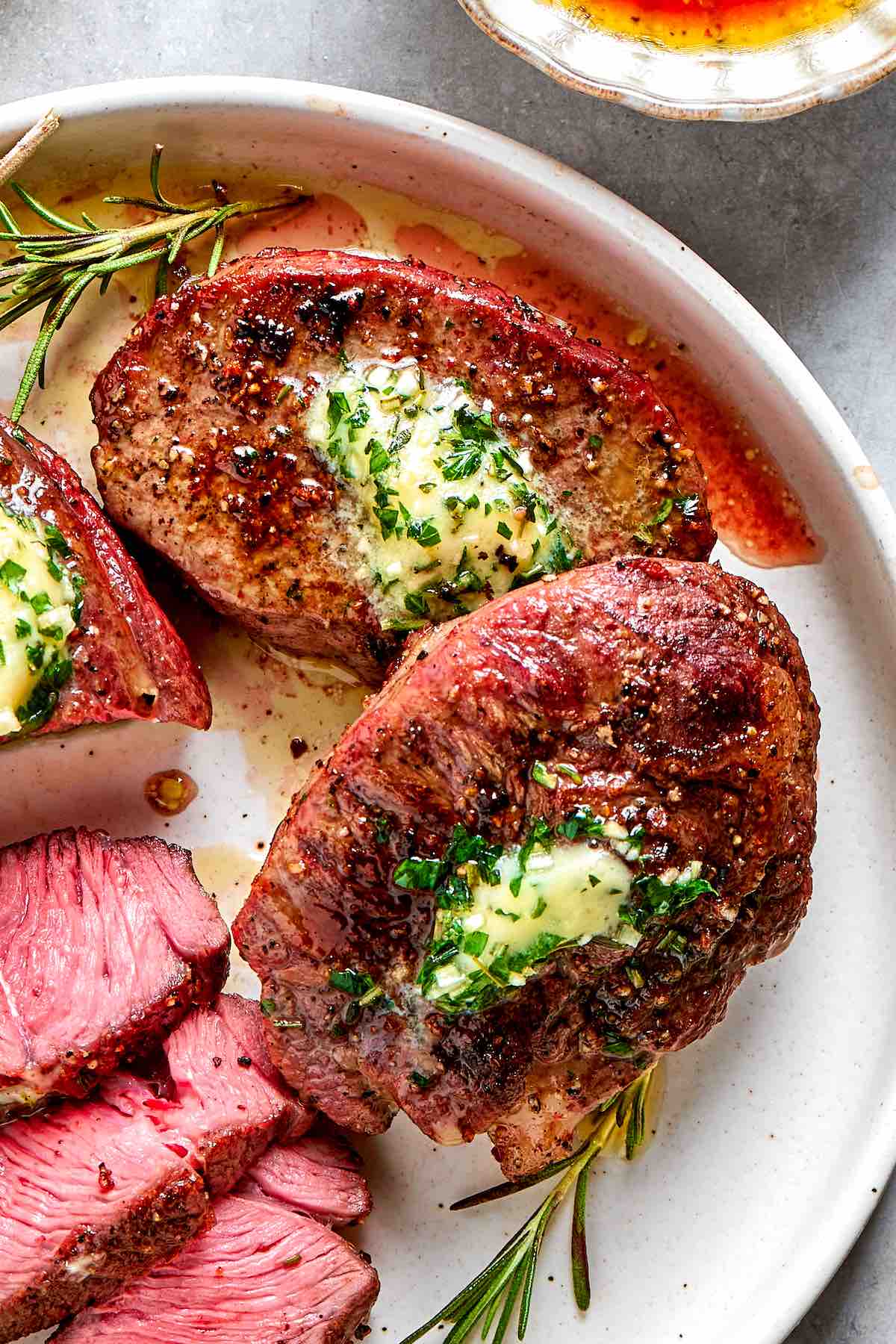 filet mignon on a plate with garlic butter.