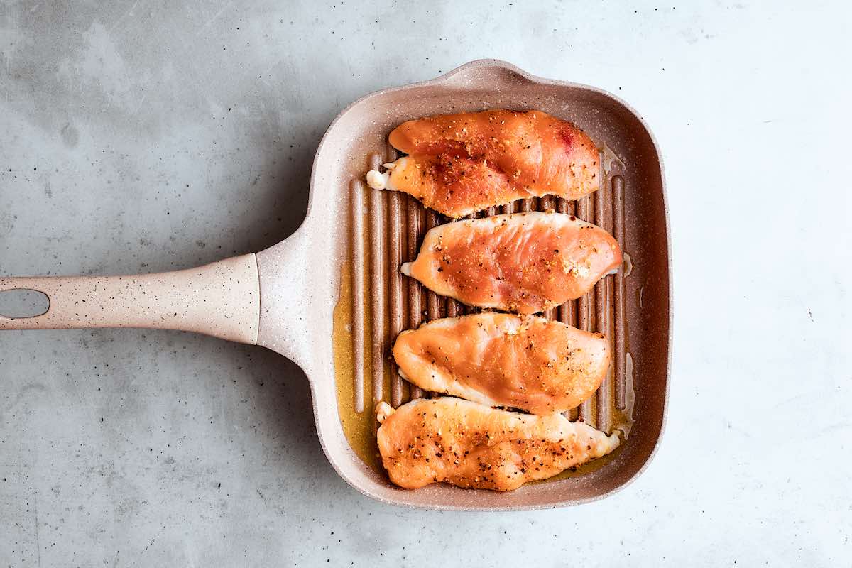 pan-searing chicken breasts on a skillet.
