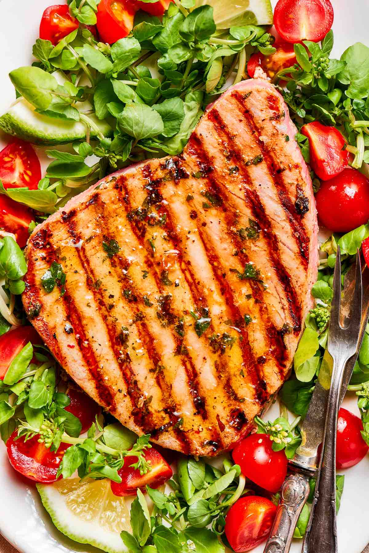grilled tuna steak over a salad.