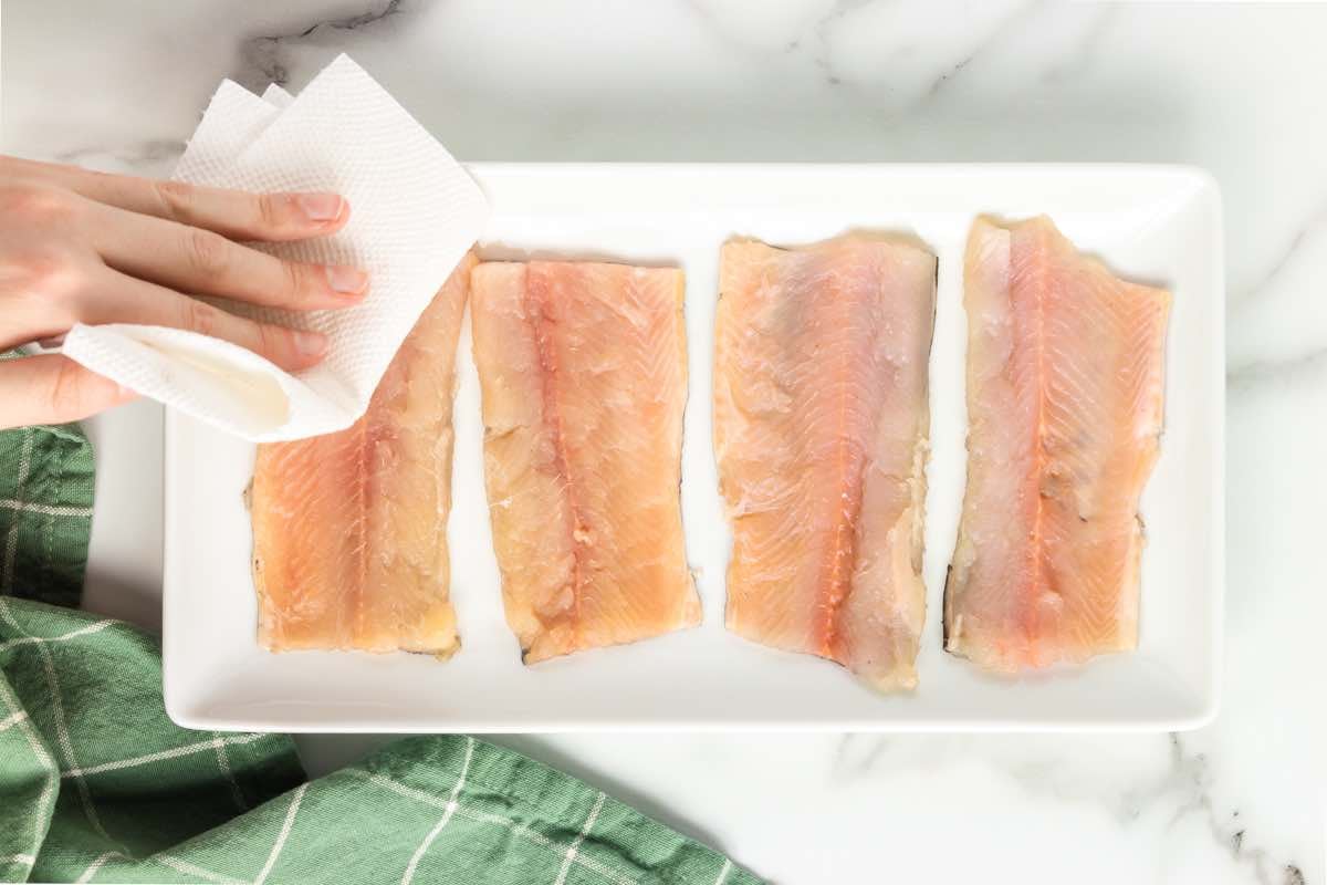 raw rainbow trout fillets on a plate.