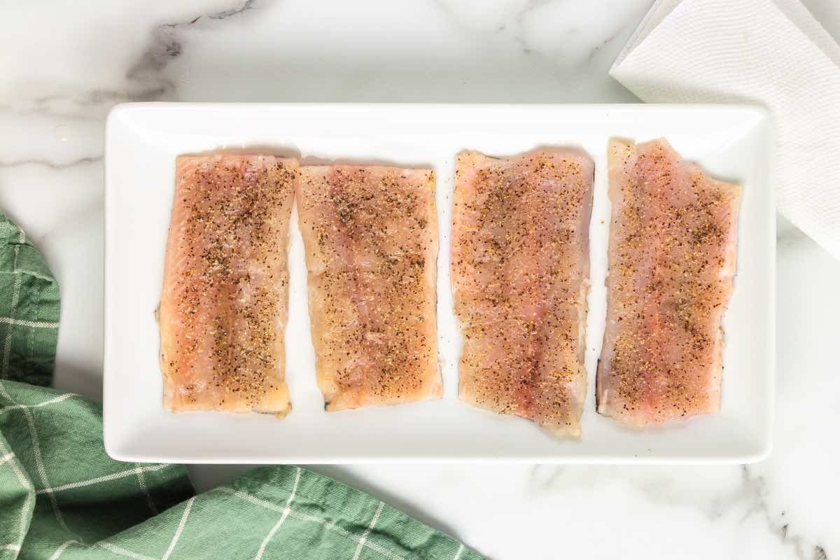 raw rainbow trout fillets seasoned with salt and pepper.