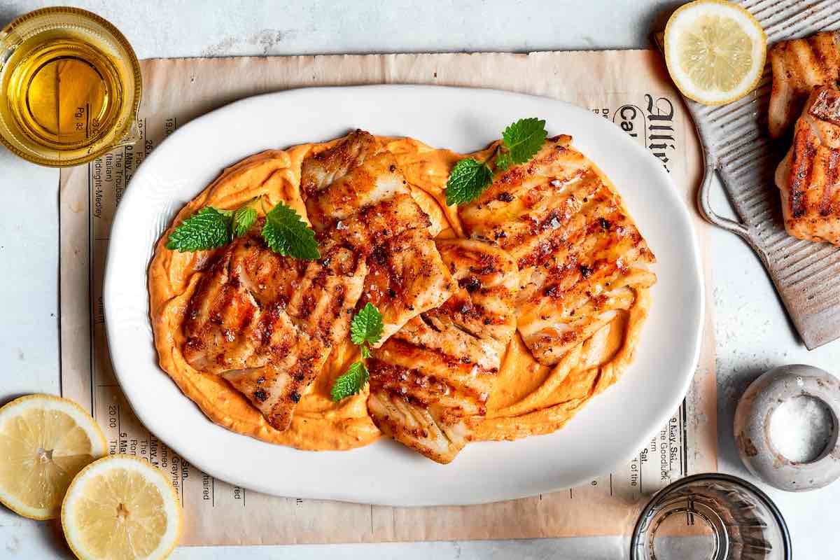 freshly grilled cod fillets on a plate.