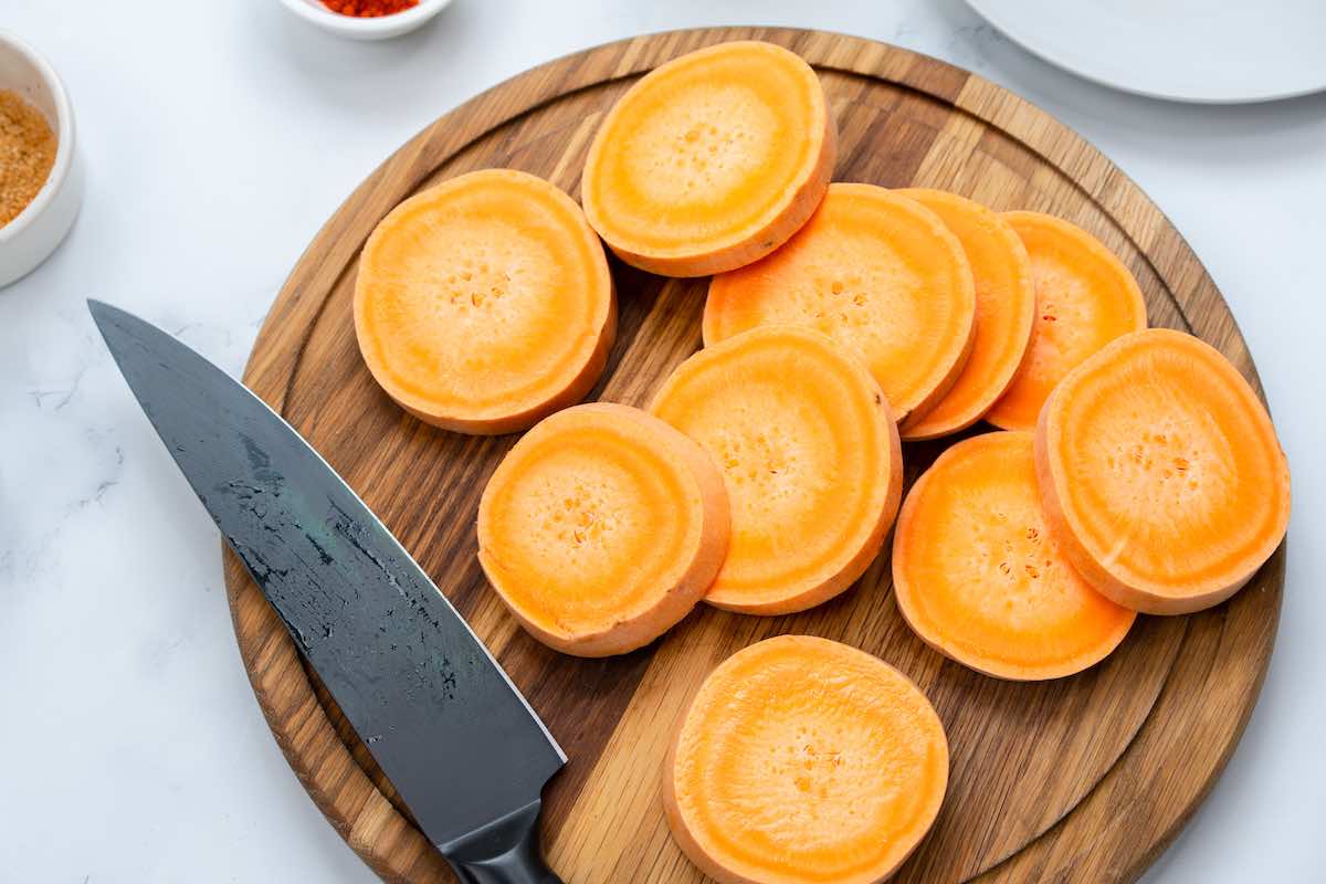 slices of raw sweet potato on a chopping board.