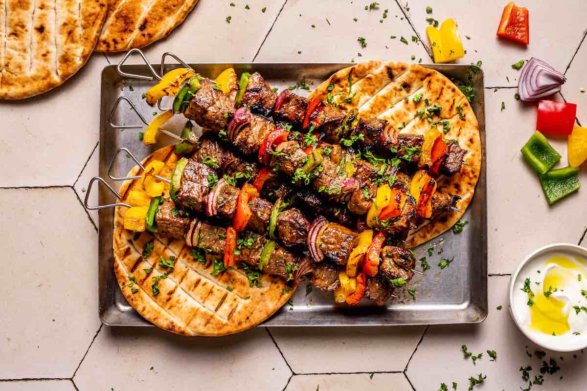 grilled beef kabobs with pita bread with fresh herbs.