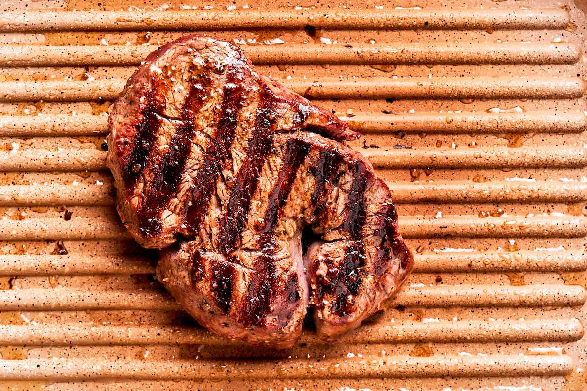 steak cooking in a cast iron skillet.