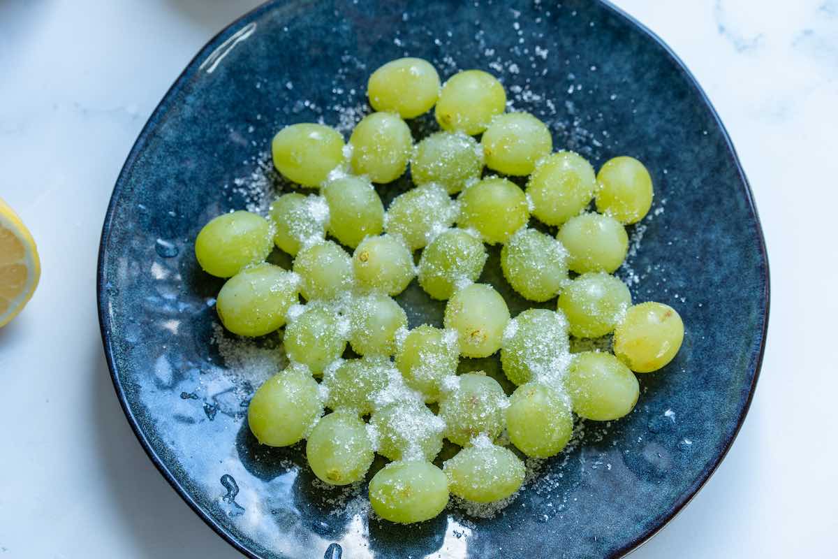 sugar tossed through grapes in a bowl.