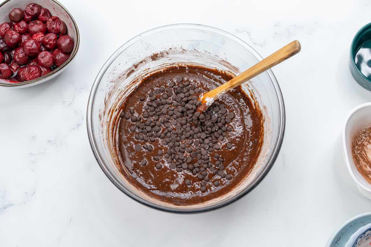 brownie batter in a bowl with chocolate chips added in.