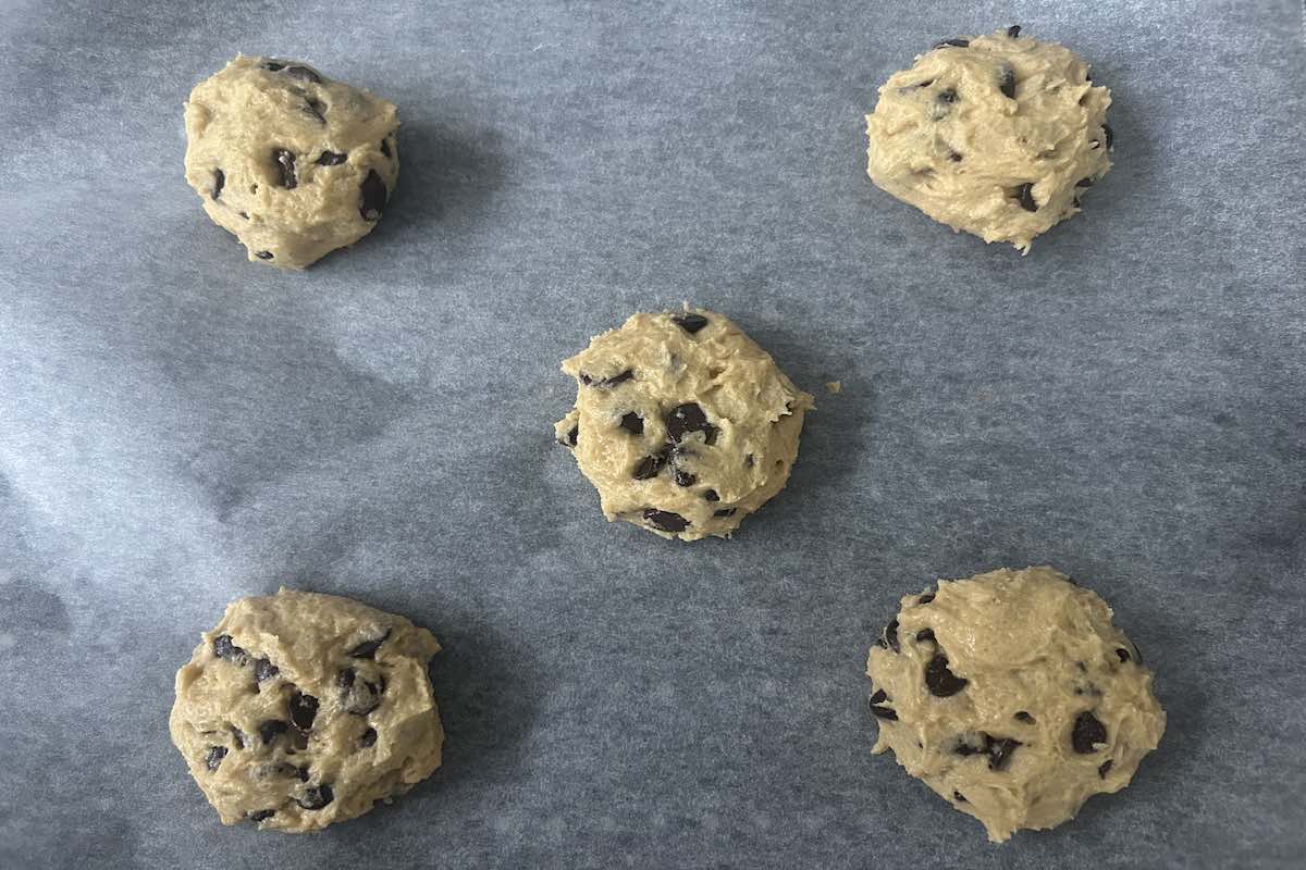 balls of dairy free chocolate chip cookie dough on a baking sheet.
