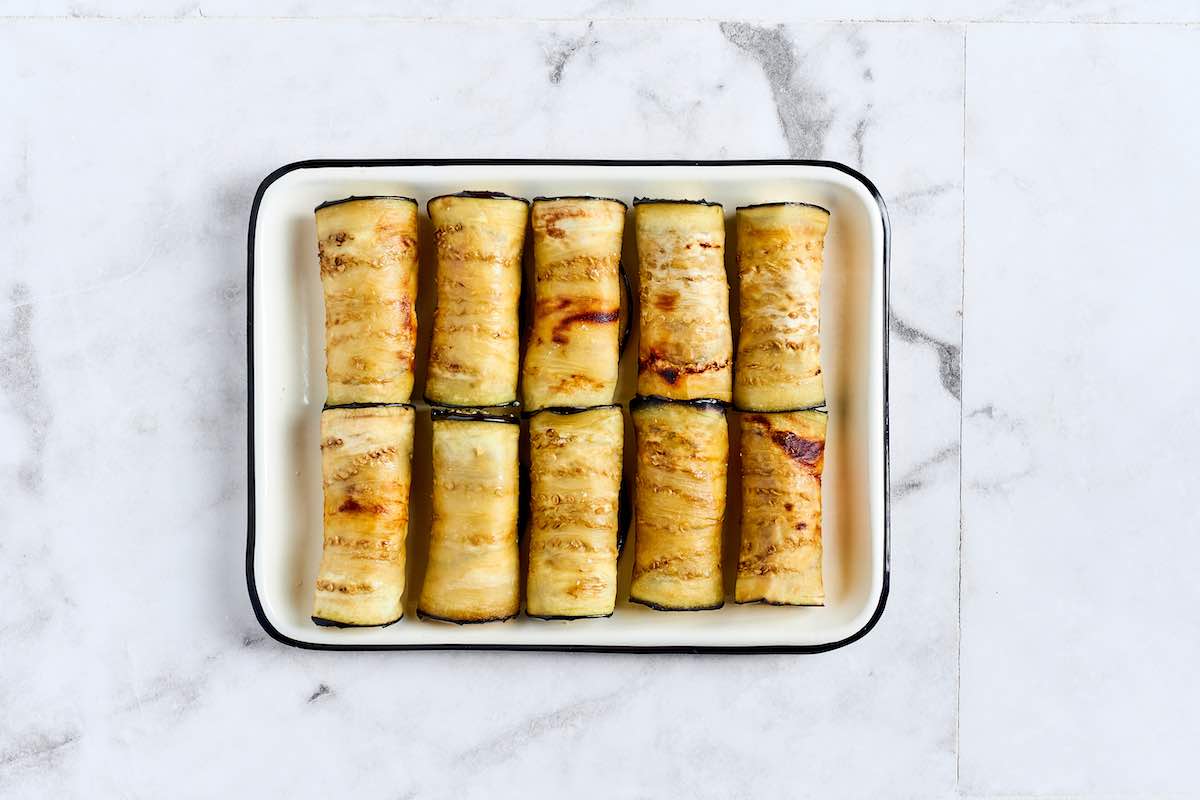 stuffed eggplant rolls in a baking dish.