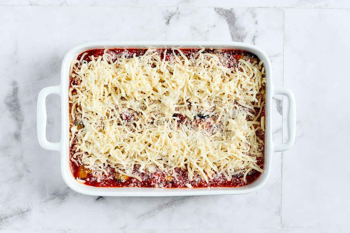 assembled eggplant rolls with tomato sauce and cheese on top.