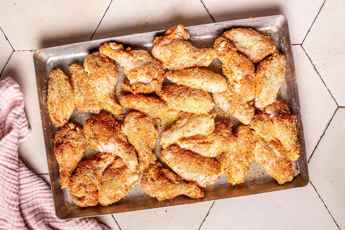 seasoned raw chicken wings on a tray.