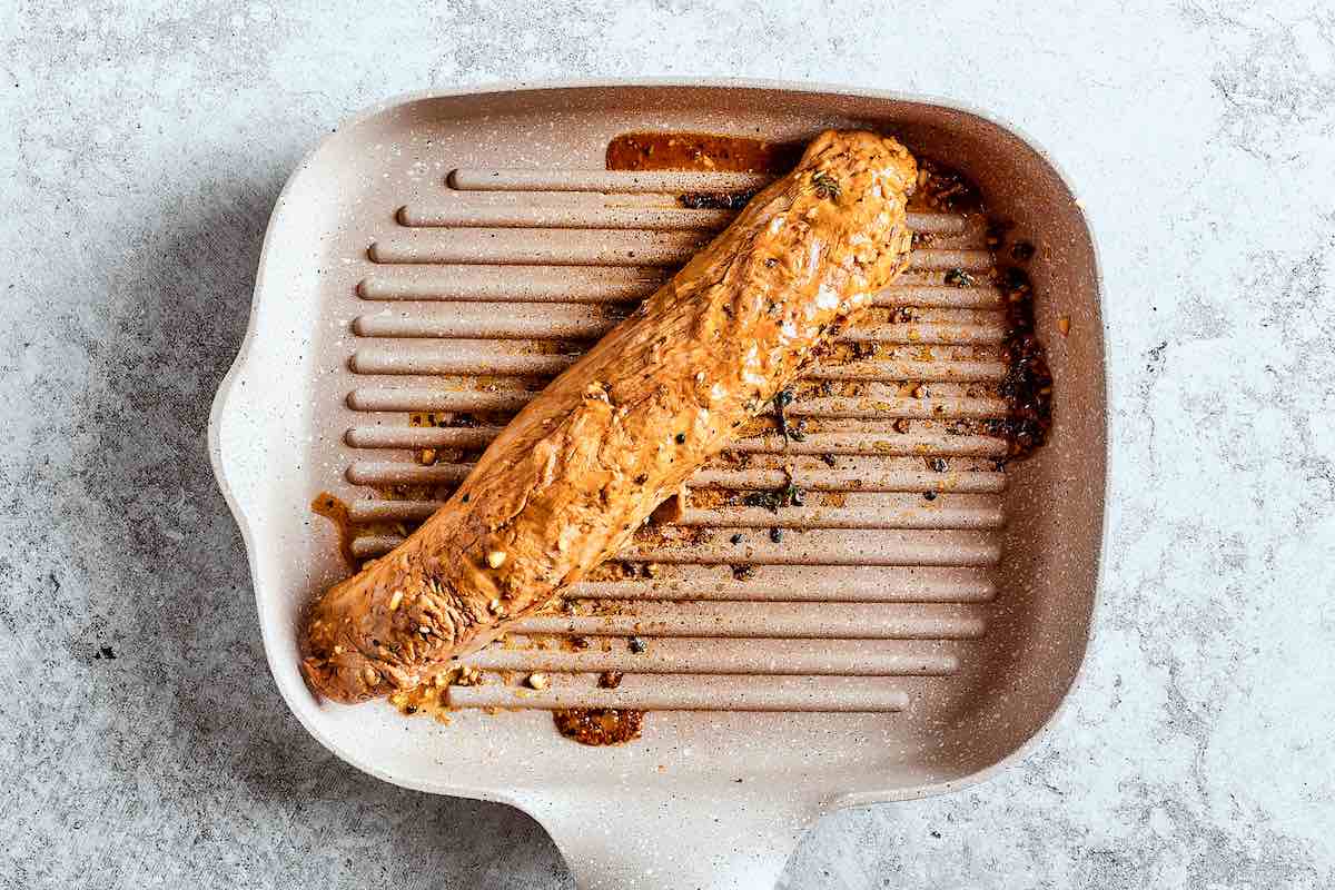 pork tenderloin grilling in a pan.
