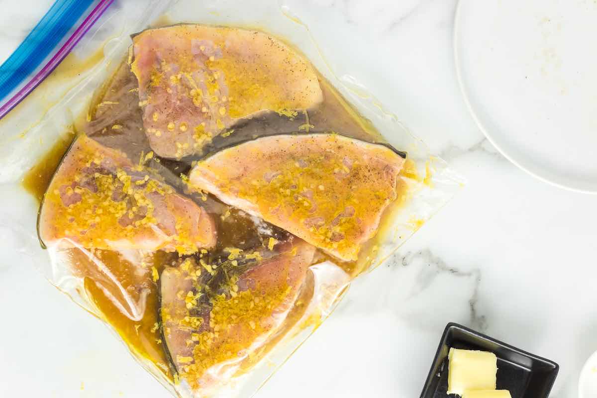 raw swordfish fillets in a ziplock bag with marinade.
