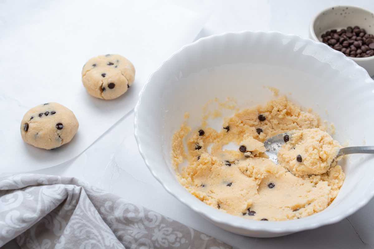 shaping balls of cookie dough on a baking sheet.