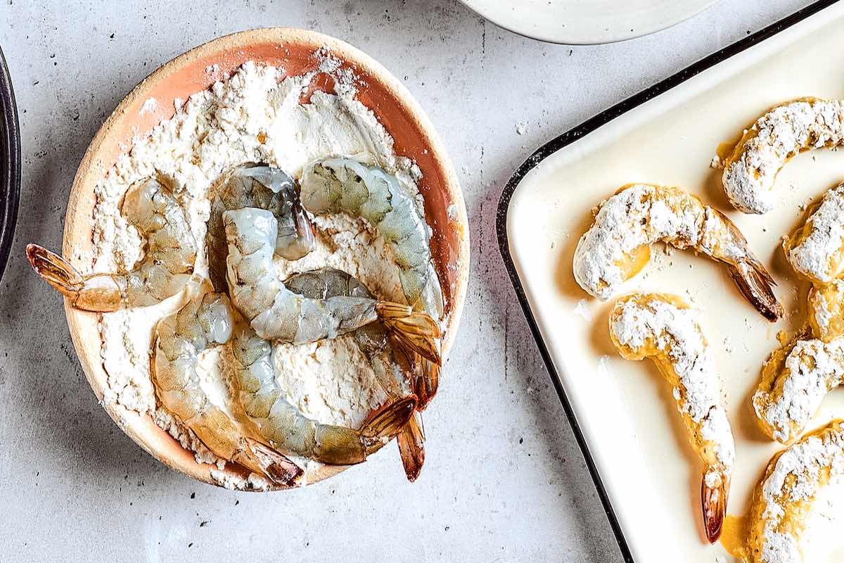 coating shrimp in flour.